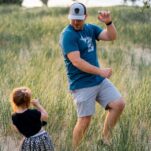 dad and daughter playing in a grass filed