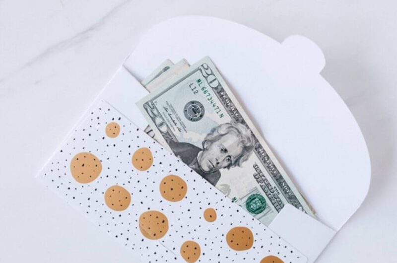 a glitter decorated envelope with a 20 dollar bill sticking out.